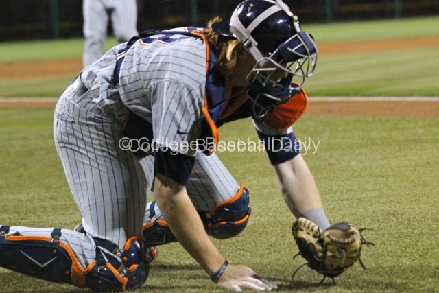 Chad Wallach looks in his glove after making a diving catch.